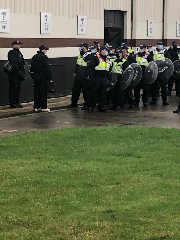 A group of police officers with riot shield lined up ready to race