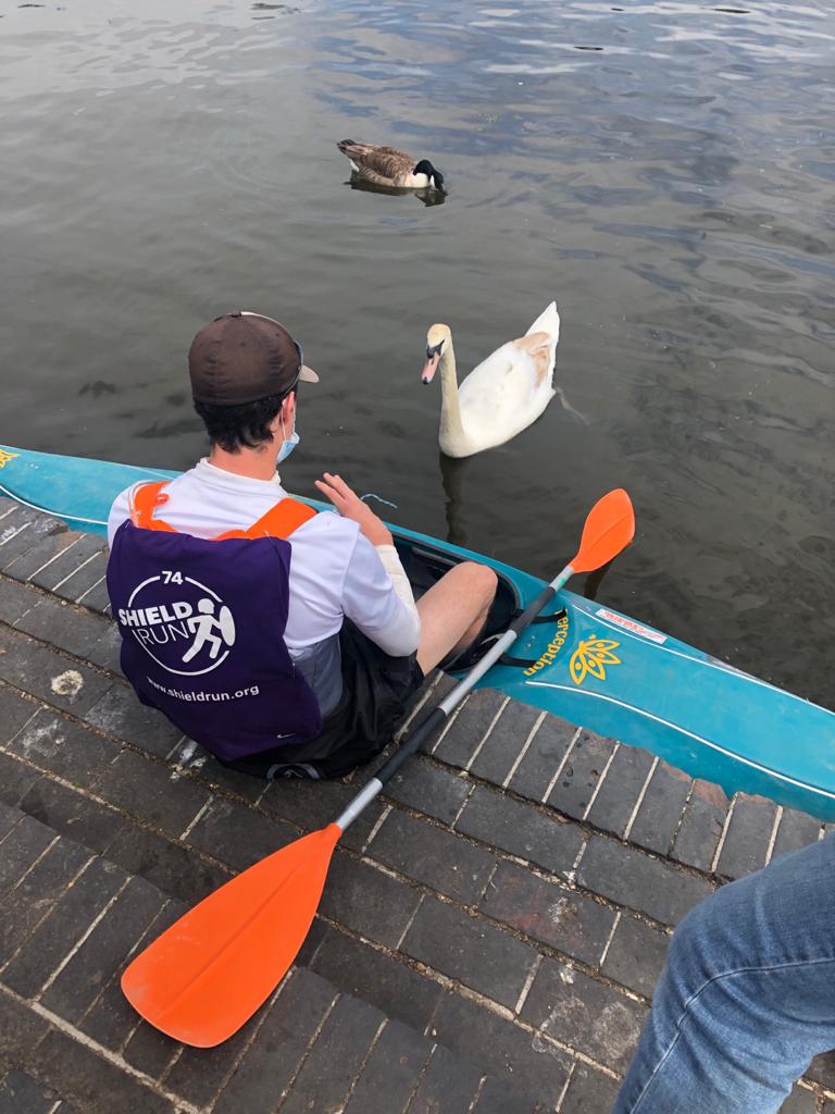 A team member meets a swan as he sits on the edge of the path