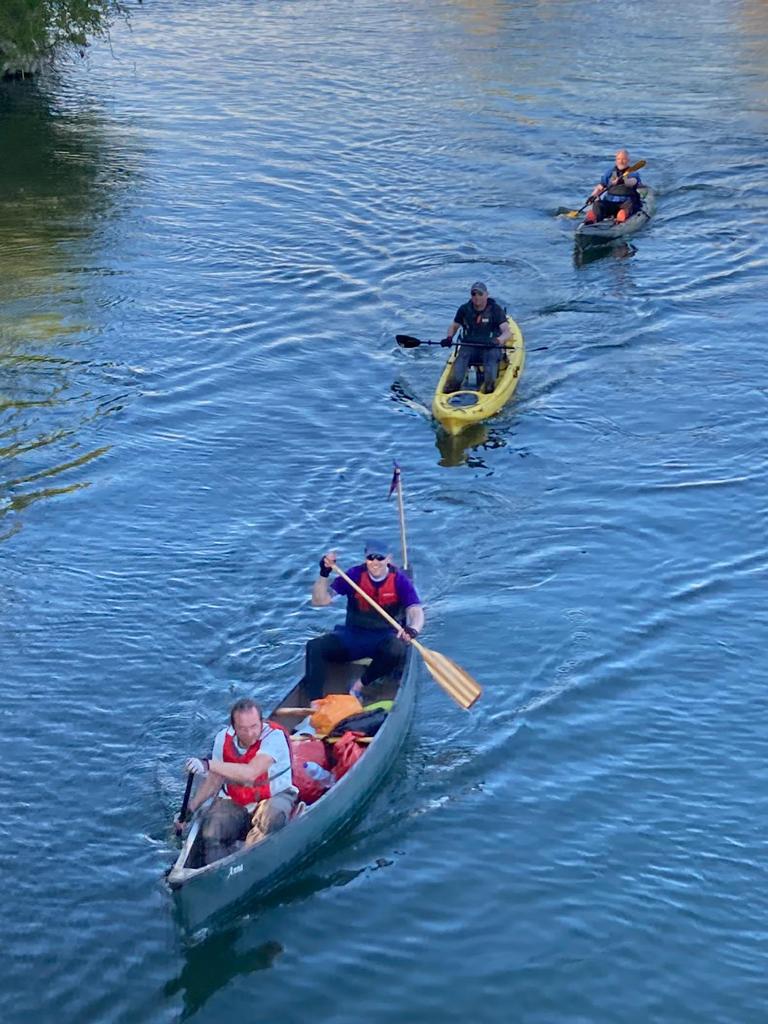 2 solo kaykers paddling behind a larger 2 person kayak