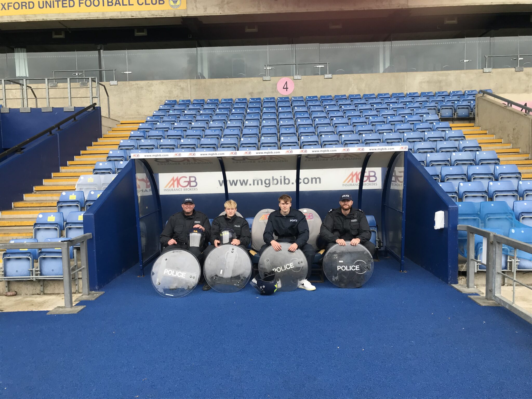 A group of 4 TVP sitting in the dugout of the Oxford United stadium